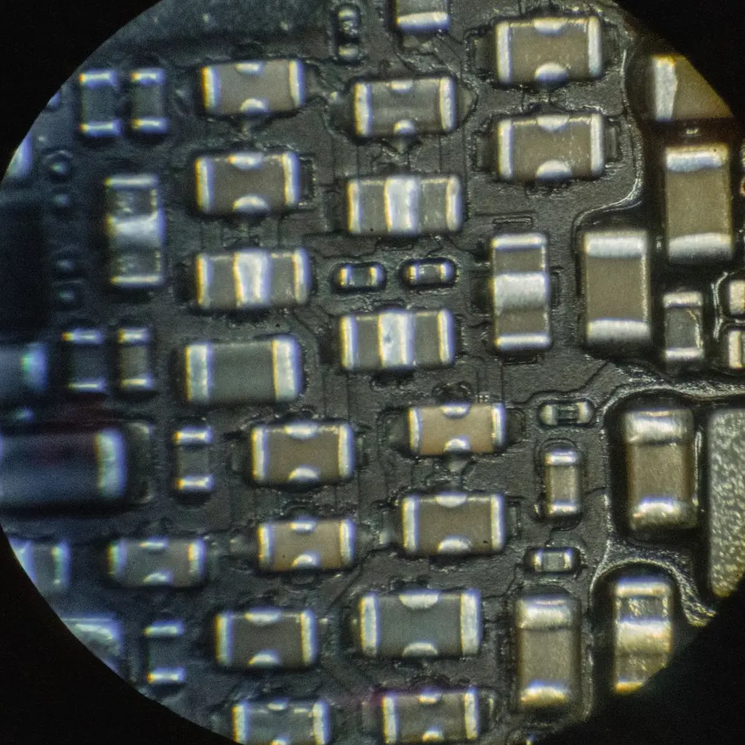 Condensateurs et résistances d'une carte mère vus à travers l'objectif du microscope